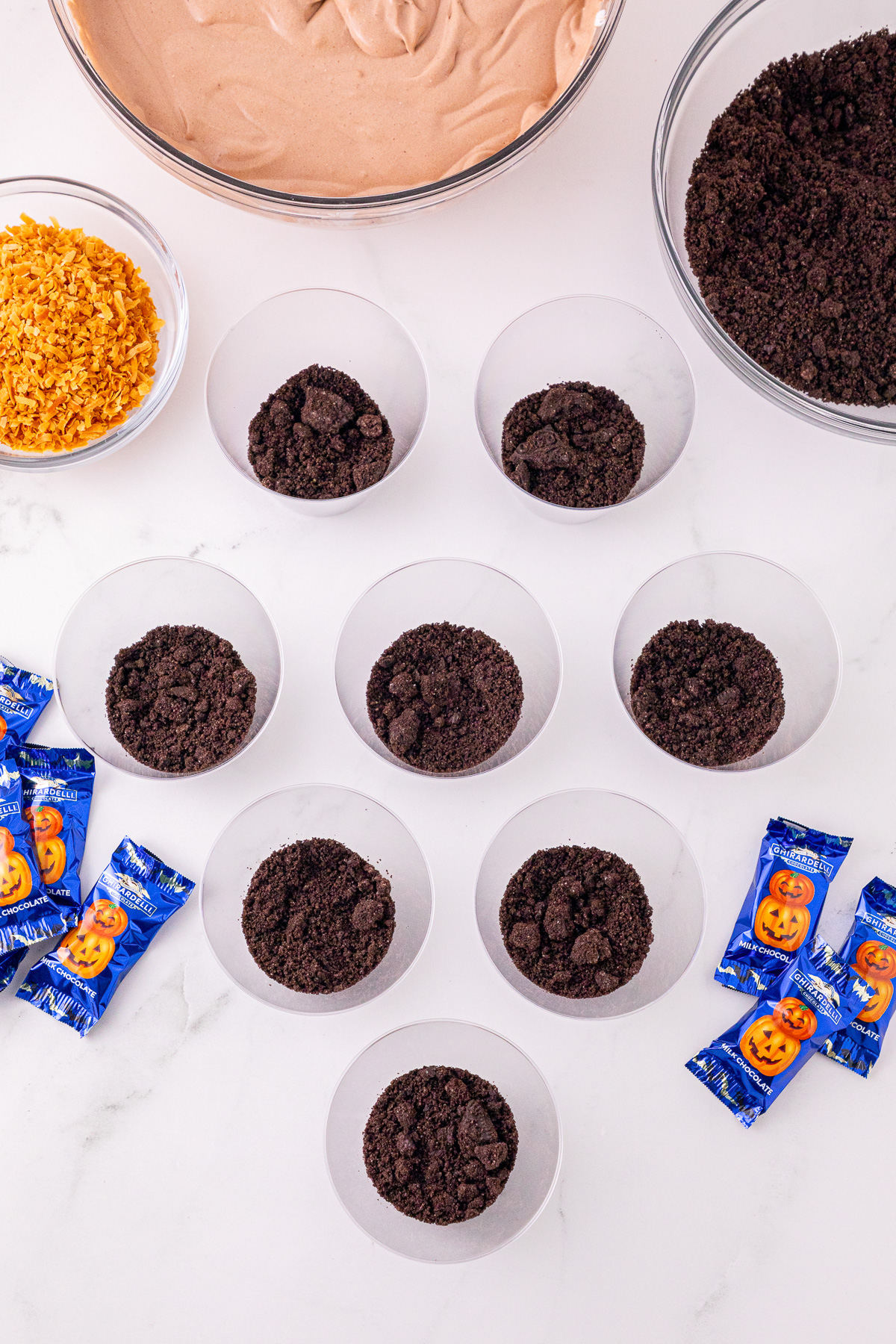 Oreo crumbs in bottom of plastic cups.