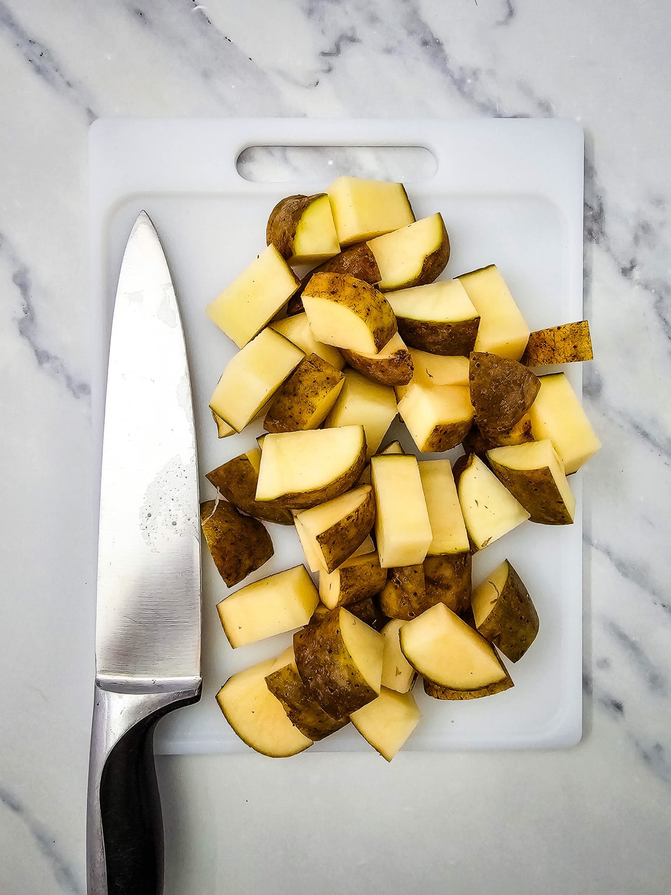 Cut potatoes on cutting board.