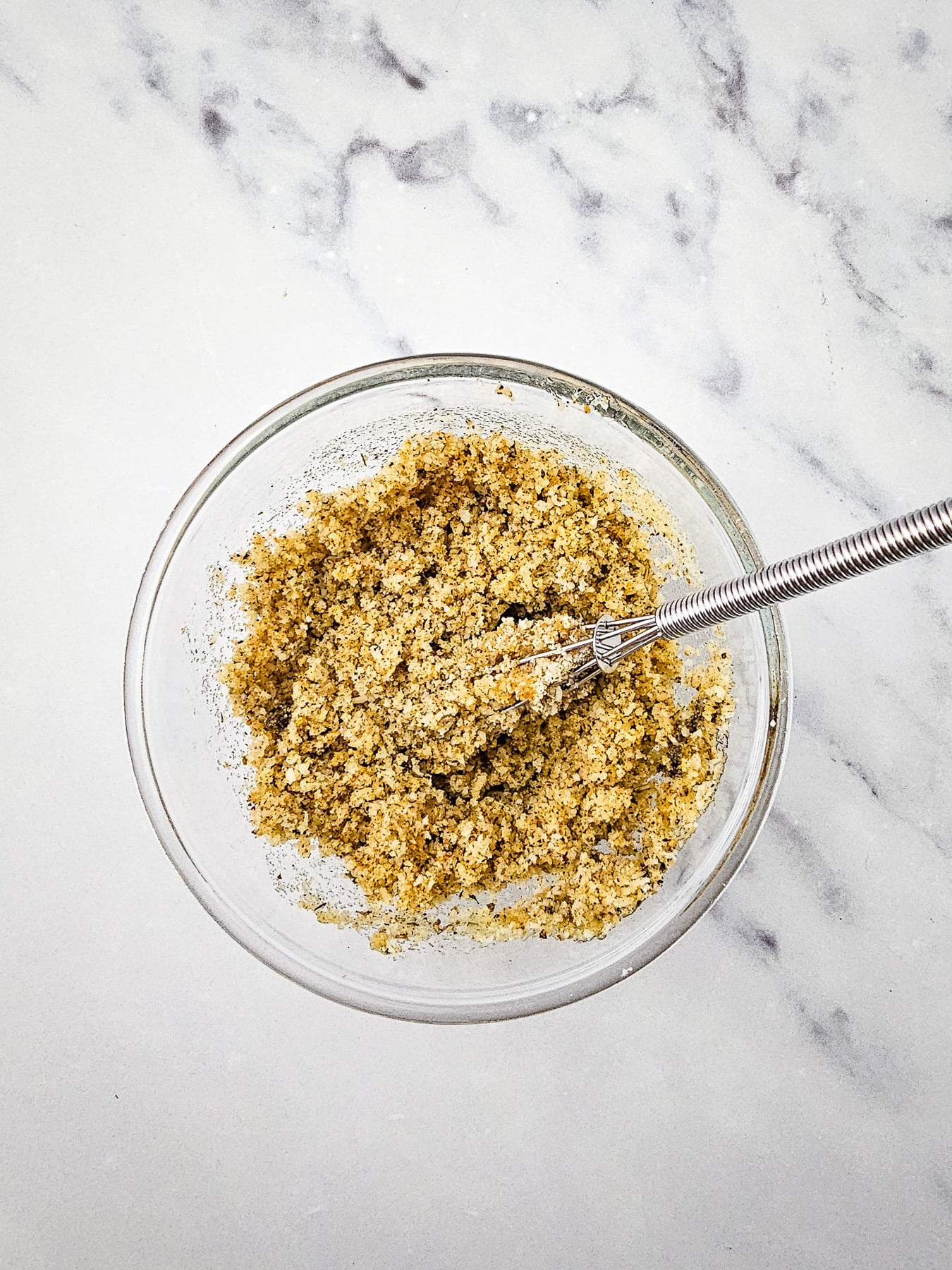 Parmesan cheese, breadcrumbs, olive oil, garlic powder, onion powder, Italian seasoning, black pepper and salt in small bowl with spoon.
