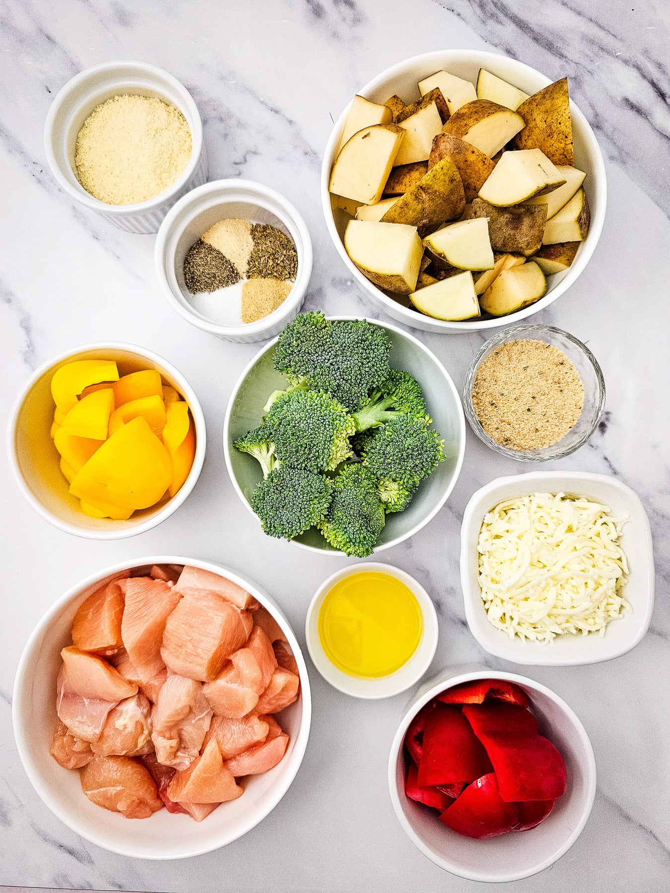 Ingredients for sheet pan mozzarealla chicken in small bowls on kitchen counter.