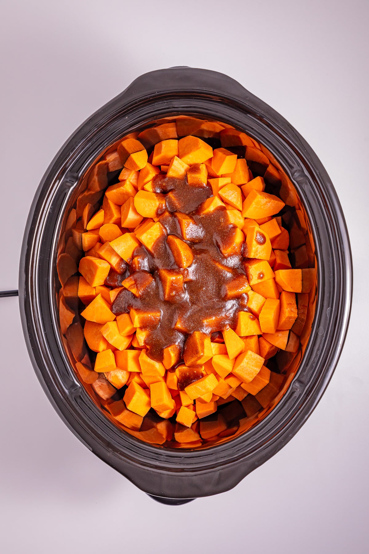 Brown sugar mixture is poured on top of the sweet potatoes in slow cooker.