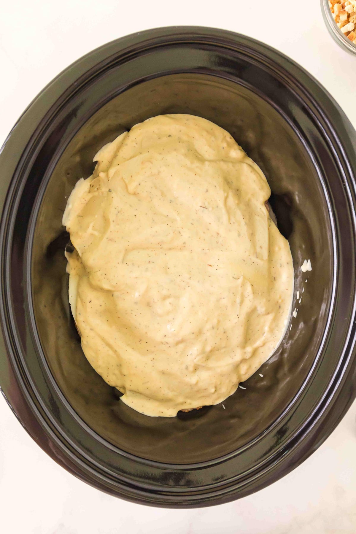 Remaining sauce is spread on top of the ingredients in slow cooker.