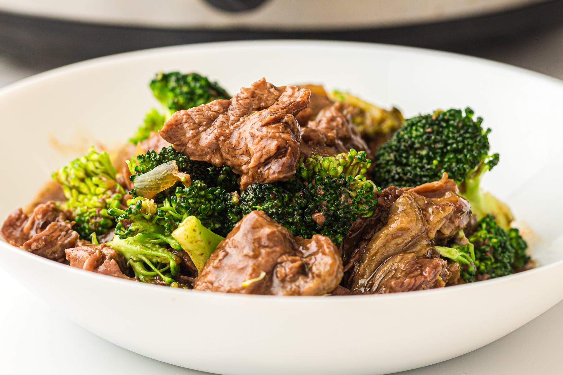 Beef and broccoli in white serving bowl ready to eat.