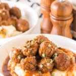 Slow cooker salisbury meatballs with mashed potatoes and gravy in a dinner bowl.