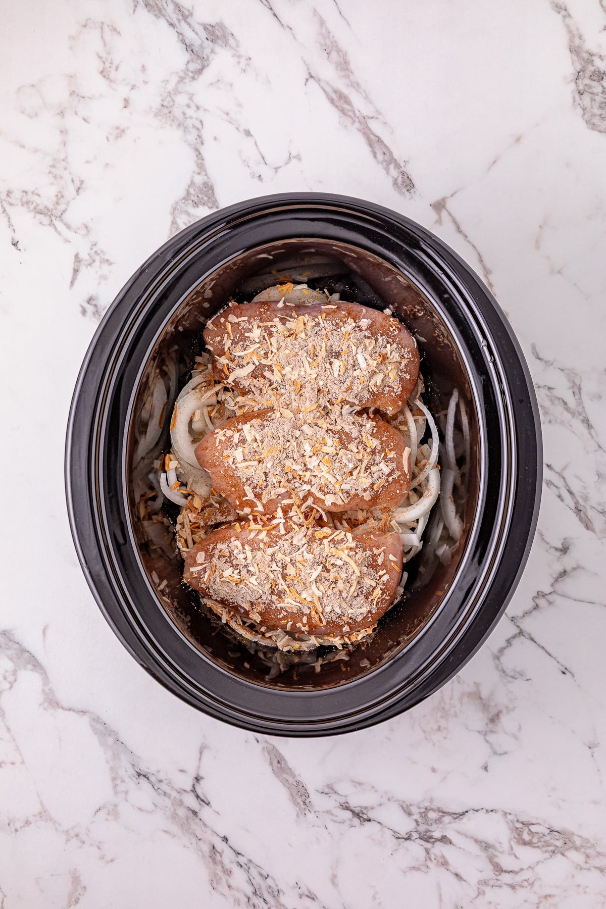 Onion soup mix is sprinkled on top of the chicken.