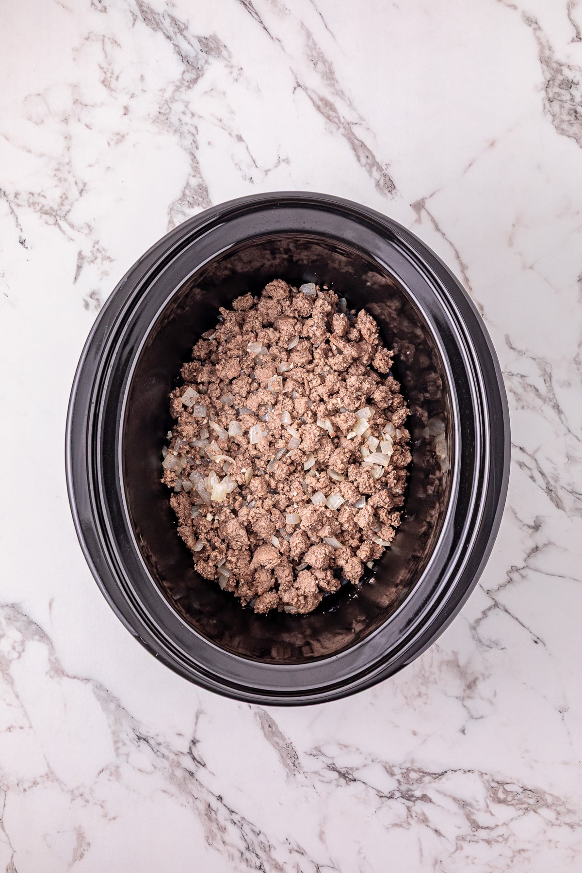 Ground beef mixture is added to the bottom of the crockpot.