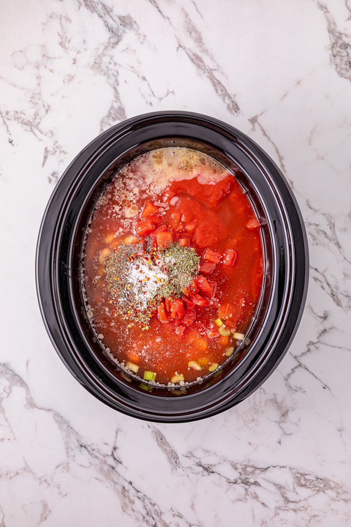 Chicken broth and add the basil, oregano, thyme, parsley, red pepper flakes, salt, and pepper in crockpot.